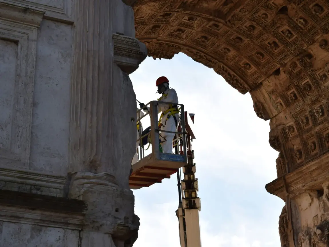 Denkmalpflege Student auf einer Hebebühne restauriert antike römische Architektur